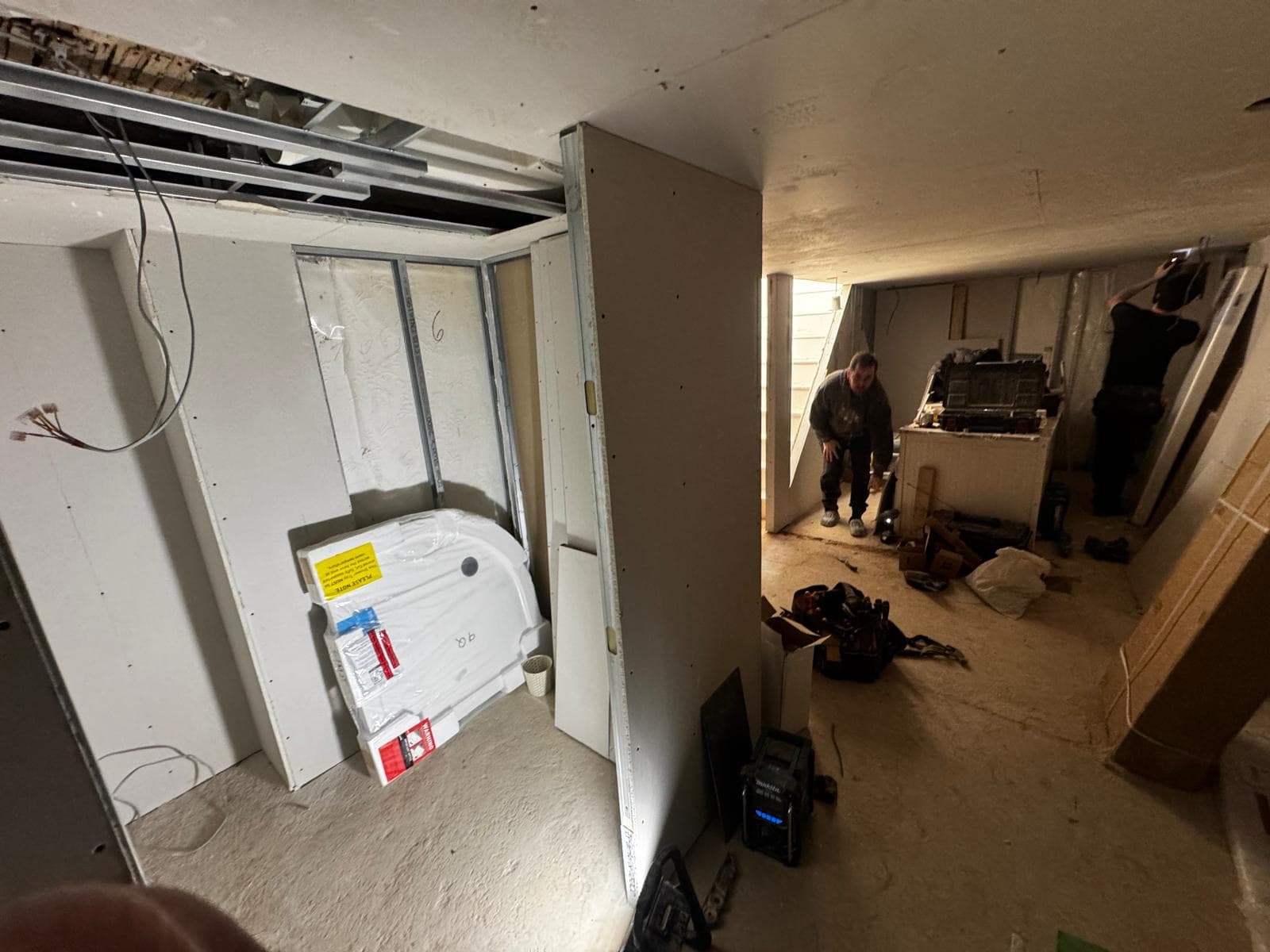 Quadrant shower tray positioned in the new studwork while first fix carries on across the rest of the basement