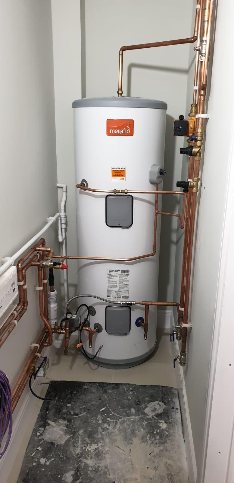 Megaflo unvented hot water cylinder installed by LJS with neat copper pipework in a Stevenage airing cupboard