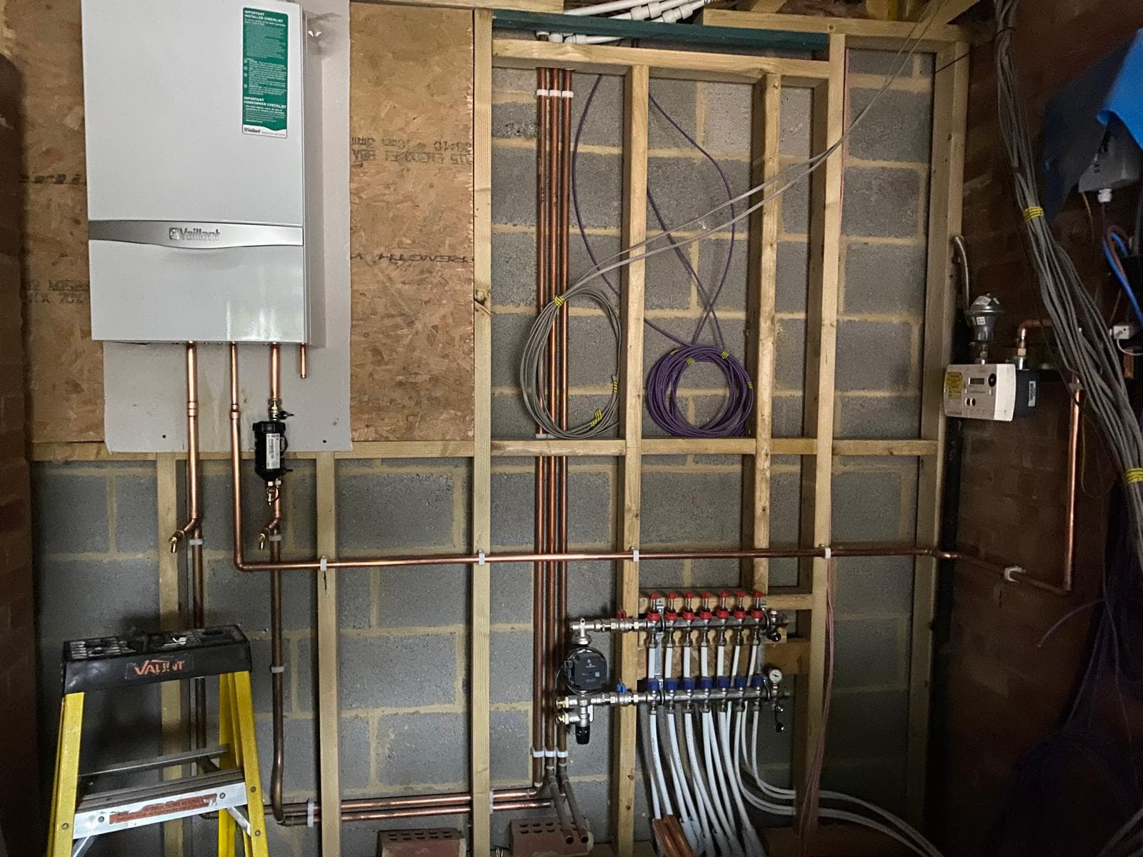 Vaillant boiler with new copper pipework and an underfloor heating manifold installed by LJS in a Stevenage utility room